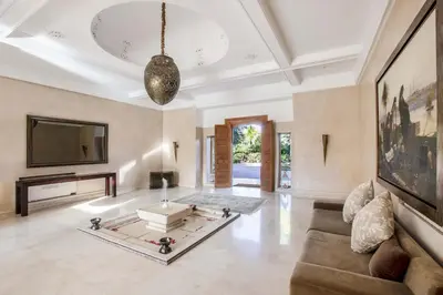 a living room with a couch and a tv at Dar Neylla in Douar Caïd Layadi