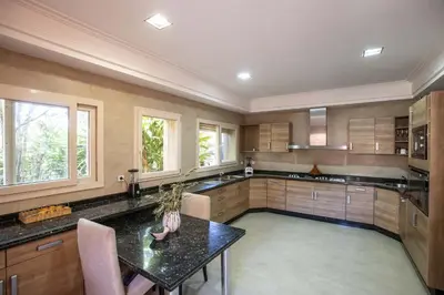 a large kitchen with a table and some windows at Dar Neylla in Douar Caïd Layadi