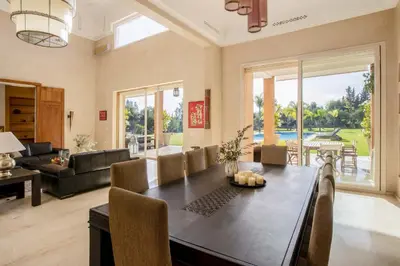 a dining room with a table and a living room at Dar Neylla in Douar Caïd Layadi