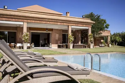 a house with a swimming pool with chairs next to it at Dar Neylla in Douar Caïd Layadi