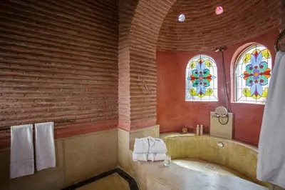 a bathroom with a tub and stained glass windows at Ame-Za in Douar Soukkane