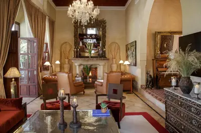 a living room with a fireplace and a chandelier at Ame-Za in Douar Soukkane