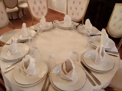 a table with white plates and utensils and napkins at ferme Walila in Douar Doukkara