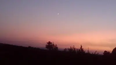 a sunset with the moon in the sky at ferme Walila in Douar Doukkara