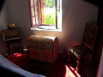 a bedroom with a chair and a window at ferme Walila in Douar Doukkara