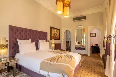 a bedroom with a large bed with a large headboard at Superbe Villa Y - Calme & sureté - Piscine privée & gouvernante in Marrakech