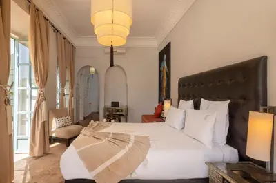 a bedroom with a large white bed with a black headboard at Superbe Villa Y - Calme & sureté - Piscine privée & gouvernante in Marrakech