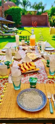 a picnic table with food and utensils on it at Superbe Villa Y - Calme & sureté - Piscine privée & gouvernante in Marrakech