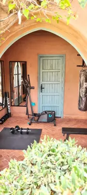 an indoor gym with exercise equipment in front of a door at Superbe Villa Y - Calme & sureté - Piscine privée & gouvernante in Marrakech