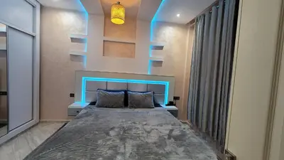 a bedroom with a bed with a blue headboard at ZR Comfort in Fès