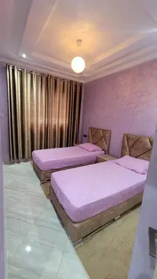three beds in a room with purple walls at ZR Comfort in Fès