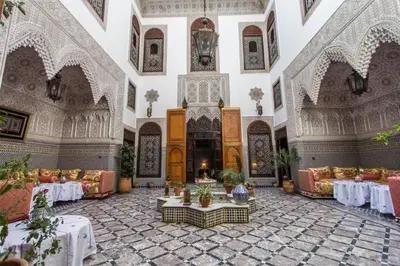 a large room with tables and chairs in a building at Riad Pacha Palace in Fès