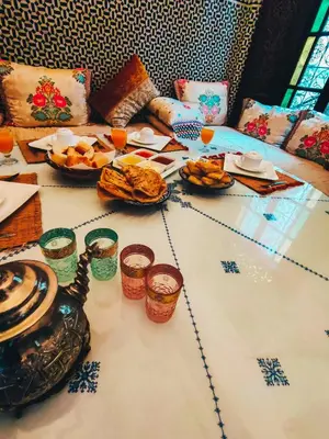 a table with plates of food and drinks on it at Riad Pacha Palace in Fès