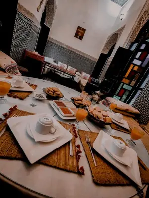 a table with plates and napkins on top of it at Riad Pacha Palace in Fès