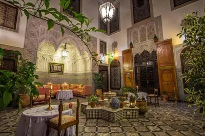 a large room with tables and chairs in a building at Riad Pacha Palace in Fès