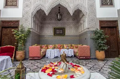 a living room with a table and a couch and a bowl of fruit at Riad Pacha Palace in Fès