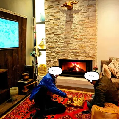 two people playing a video game in front of a fireplace at Maurice Bonjean in Ifrane