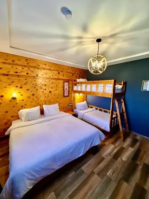 a bedroom with two beds and a chandelier at Maurice Bonjean in Ifrane