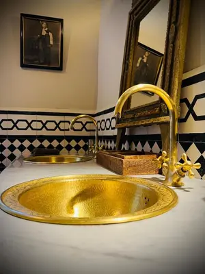 a bathroom with a gold sink and a mirror at Aux portes de Marrakech Villa Arts & Déco avec piscine in Marrakech