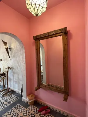 a bathroom with a mirror on a pink wall at Boutique Guesthouse Dar Zohra in Marrakech