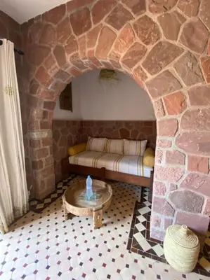 a living room with a couch and a stone wall at Boutique Guesthouse Dar Zohra in Marrakech