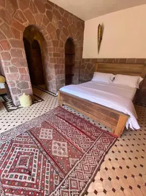 a bedroom with a bed and a rug on the floor at Boutique Guesthouse Dar Zohra in Marrakech