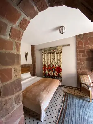 a bedroom with a bed and a brick wall at Boutique Guesthouse Dar Zohra in Marrakech