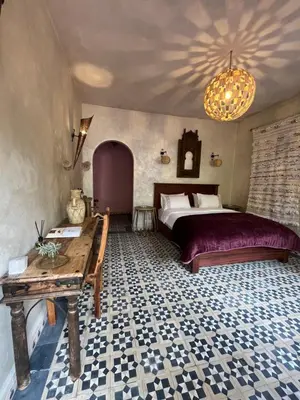 a bedroom with a bed and a table in it at Boutique Guesthouse Dar Zohra in Marrakech