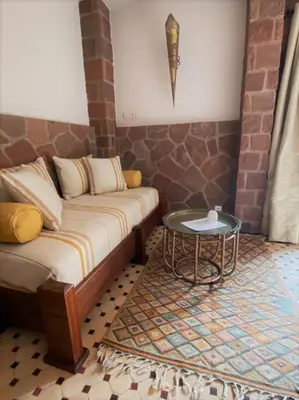 a bedroom with a bed and a table on a rug at Boutique Guesthouse Dar Zohra in Marrakech