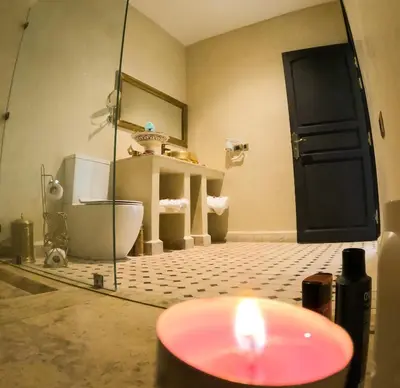 a bathroom with a toilet and a candle in a room at kasbah yu palace in Ouarzazate