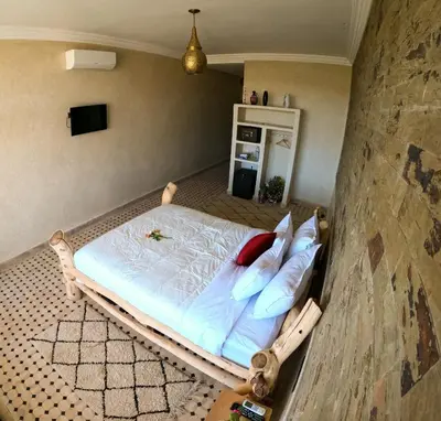a bedroom with a bed with white sheets and pillows at kasbah yu palace in Ouarzazate