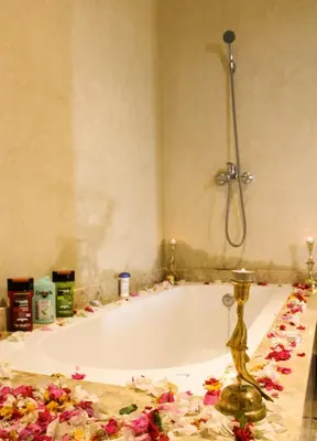 a bathroom with a bath tub with flowers on the floor at kasbah yu palace in Ouarzazate