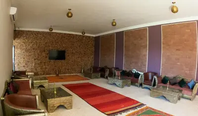 a living room with couches and a flat screen tv at kasbah yu palace in Ouarzazate