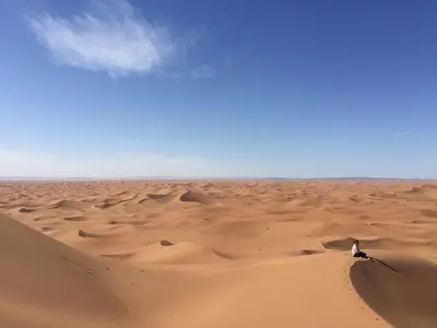 a person standing in the middle of a desert at Bivouac Erg Chegaga Nomademoi in El Gouera