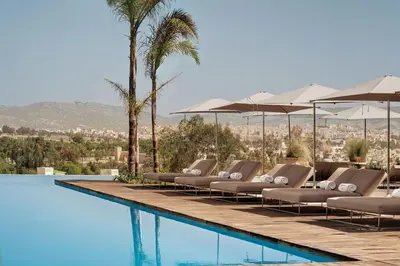 a row of lounge chairs and umbrellas next to a swimming pool at Hotel Sahrai in Fès