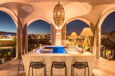 a home with a pool in a room with windows at Hotel Sahrai in Fès