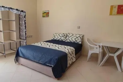 a small bedroom with a bed and a desk at Studio @khémisset in Khemisset