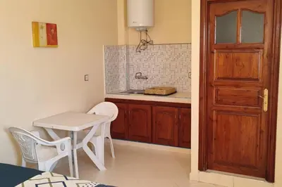 a kitchen with a table and a table and a door at Studio @khémisset in Khemisset