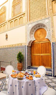a table with plates of food on it in a courtyard at Riad Sayeda Al Hora in Fès