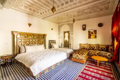 a bedroom with a large bed and a couch at Riad Sayeda Al Hora in Fès