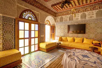 a living room with a couch and a tv at Riad Sayeda Al Hora in Fès