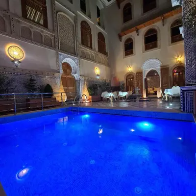 a large swimming pool in a large building with a building at Riad Sayeda Al Hora in Fès