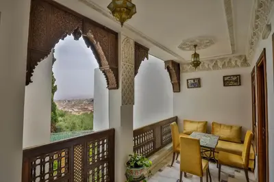 a room with a balcony with a table and chairs at Riad Fez Mahal in Fès