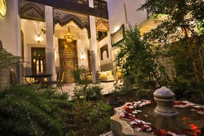 a house with a fountain in the middle of a garden at Riad Fez Mahal in Fès