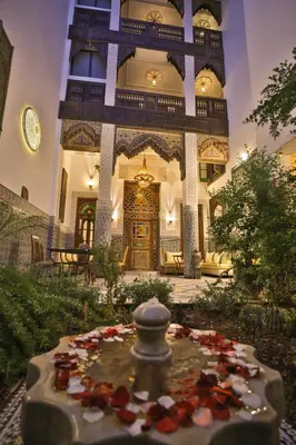 a building with a fountain in the middle of a yard at Riad Fez Mahal in Fès