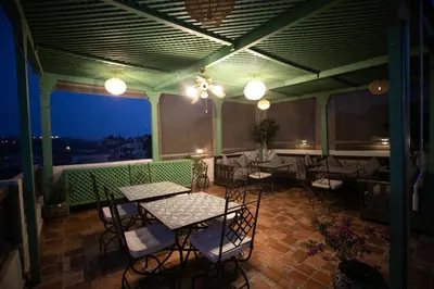a restaurant with tables and chairs on a balcony at Riad Fez Mahal in Fès