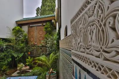 a stone wall with a garden in the background at Riad Fez Mahal in Fès