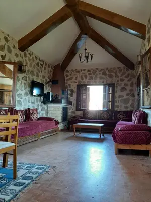 a large living room with two beds and a couch at Joli Chalet dans une ferme Pour familles exclusivement près ifrane in Azrou