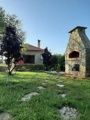 a stone house with a brick oven in a yard at Joli Chalet dans une ferme Pour familles exclusivement près ifrane in Azrou