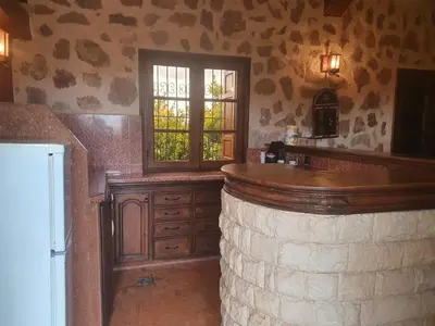 a kitchen with a large stone bar with a window at Joli Chalet dans une ferme Pour familles exclusivement près ifrane in Azrou